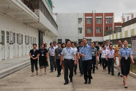 图为:市医保系统干部职工在泉州市看守所所长带领下参观看守所